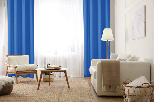 cortina azul en sala luminosa, con sillones y mesa de café