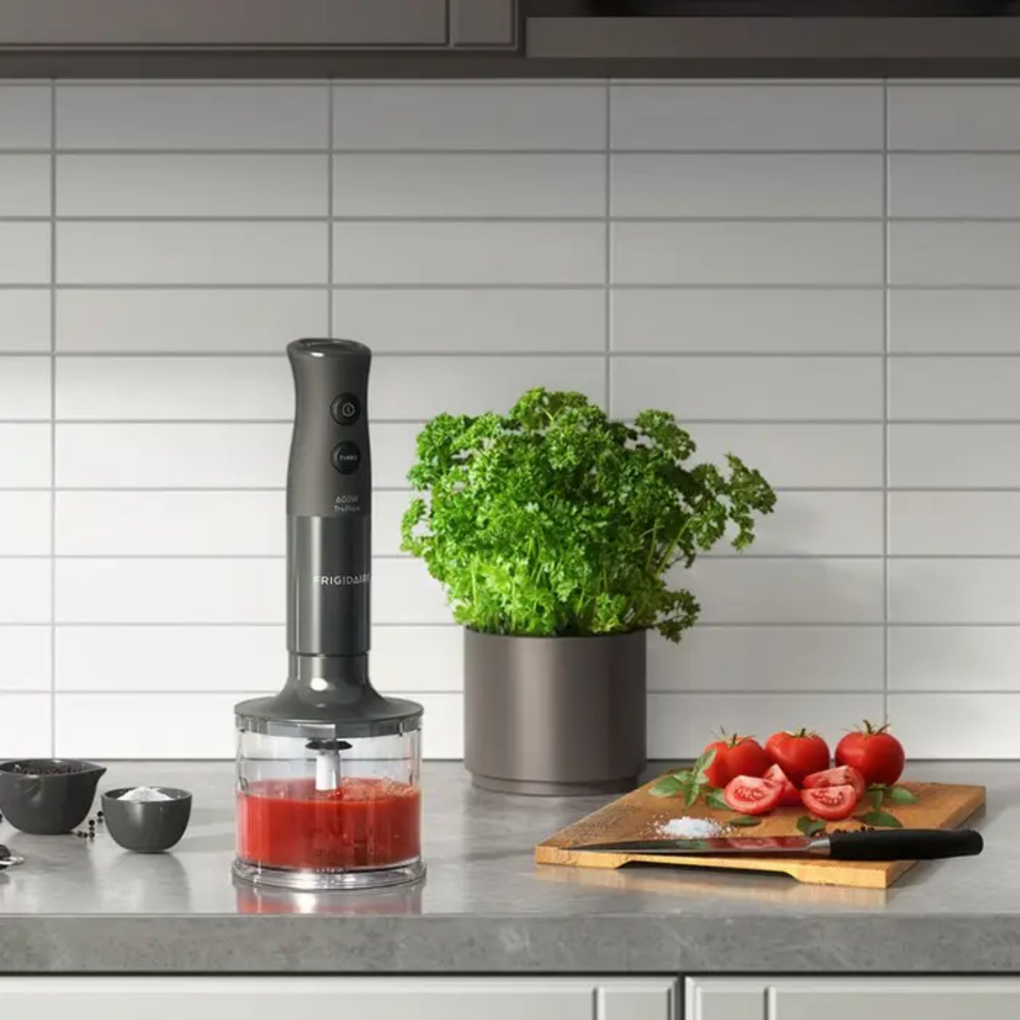 Licuadora de Frigidaire gris, vista frontal en cocina moderna con ingredientes frescos