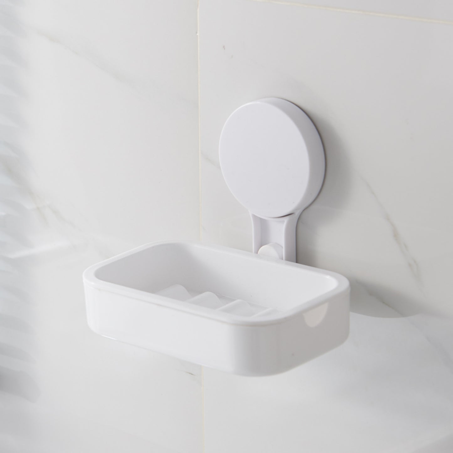 jabónera blanca montada en pared, baño con azulejos claros
