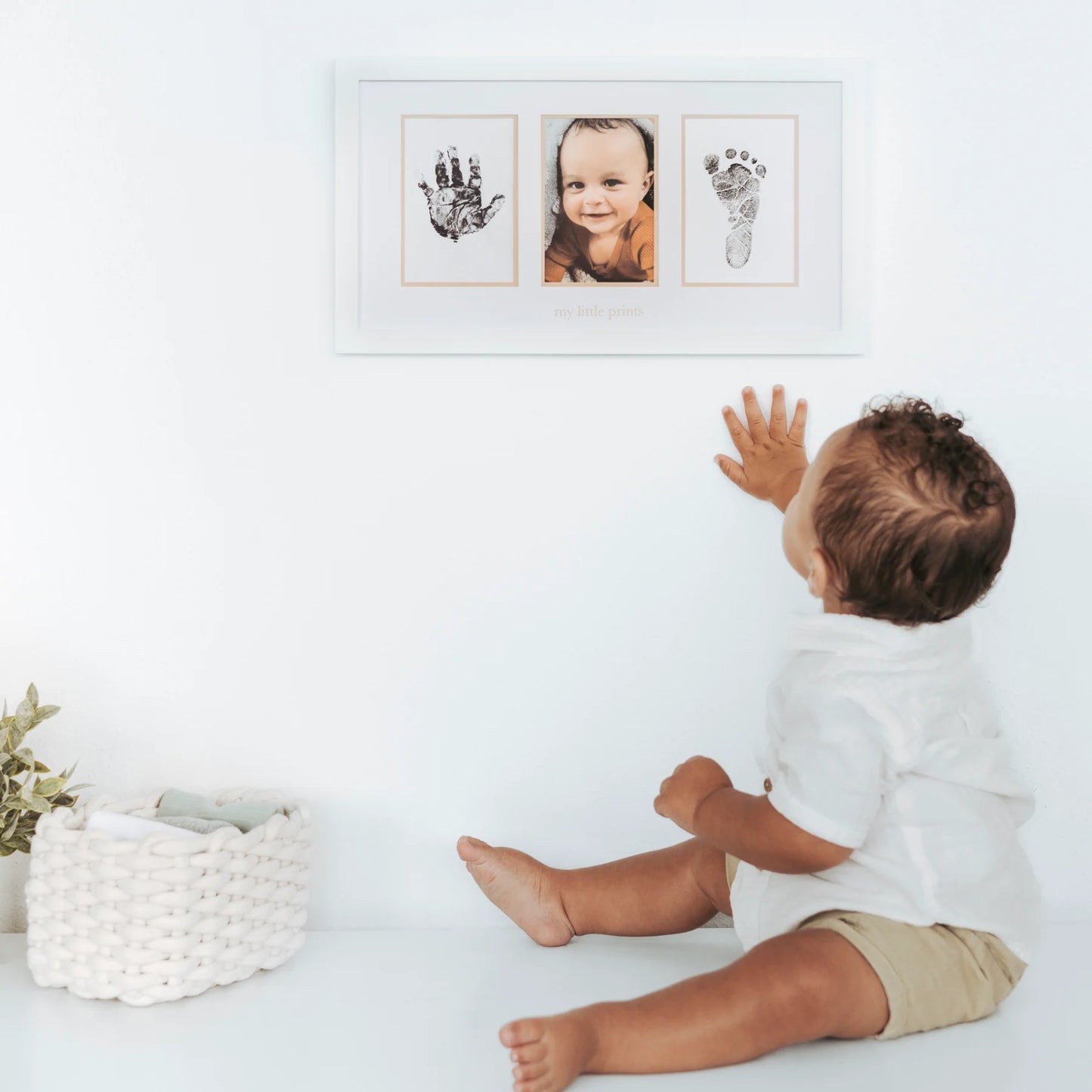 Marco de fotos blanco con huellas de bebé y retrato sonriendo, decoración infantil