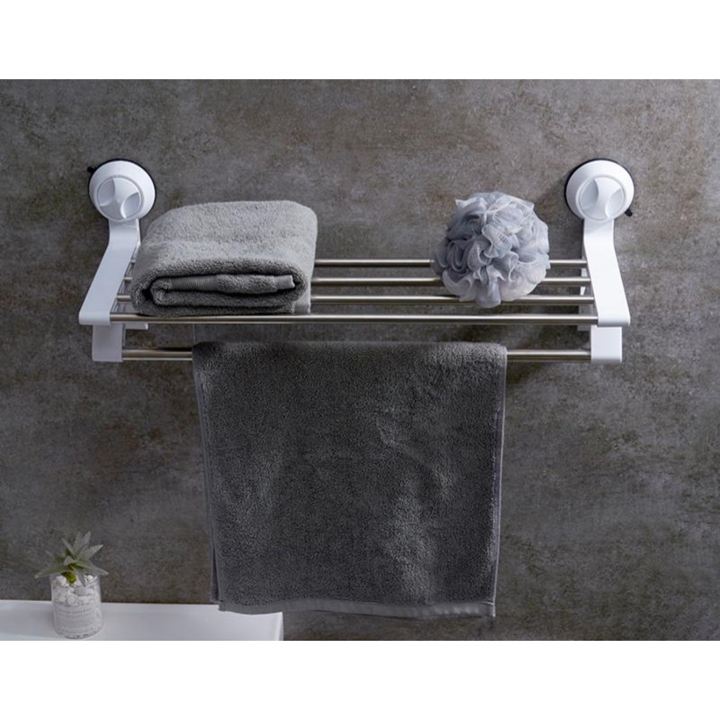 toallero blanco montado en pared con toallas grises en baño