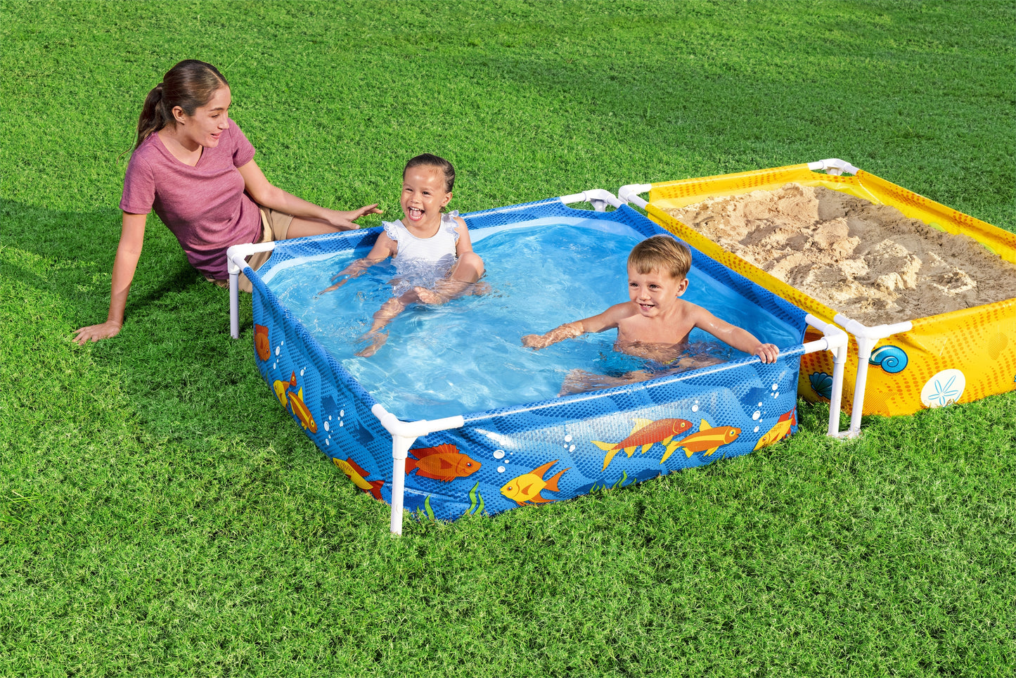 piscina infantil con tubos Bestway, niños felices jugando, césped verde