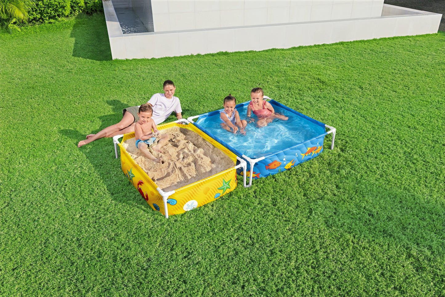 piscina infantil con tubos Bestway, vista desde arriba, niños jugando en agua y arena