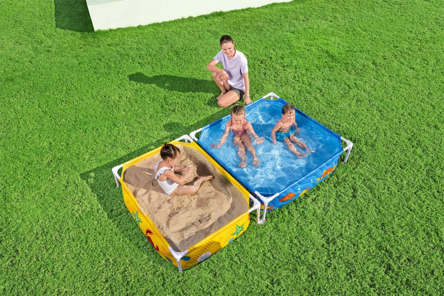 piscina infantil con tubos Bestway, vista lateral, niños jugando en arena y agua