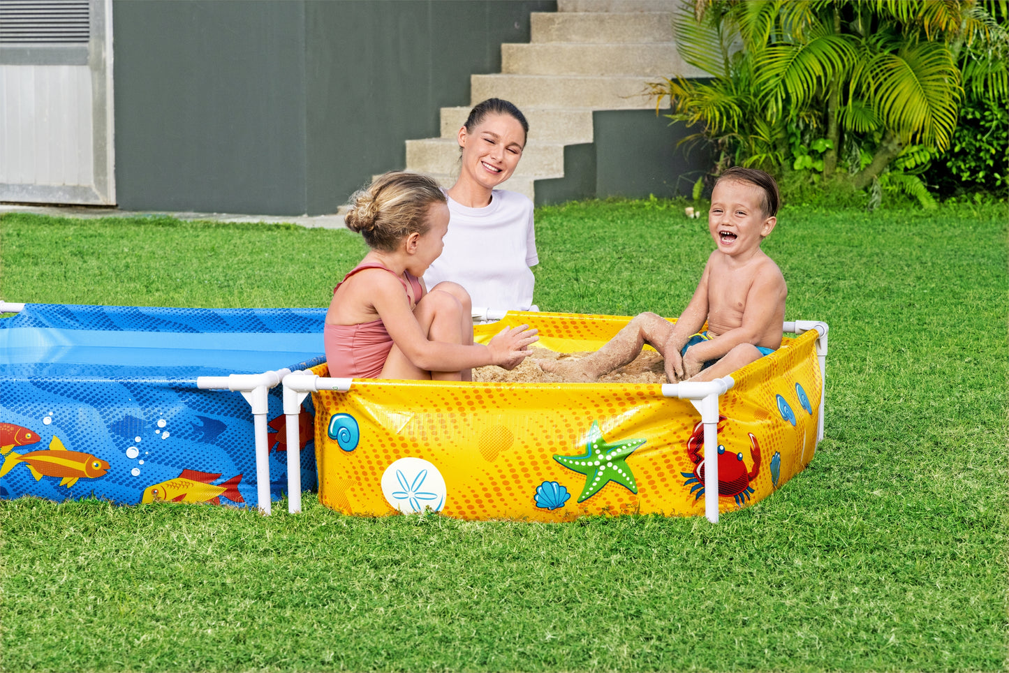 Piscina infantil con tubos Bestway, color amarillo, vista lateral en jardín con niños jugando
