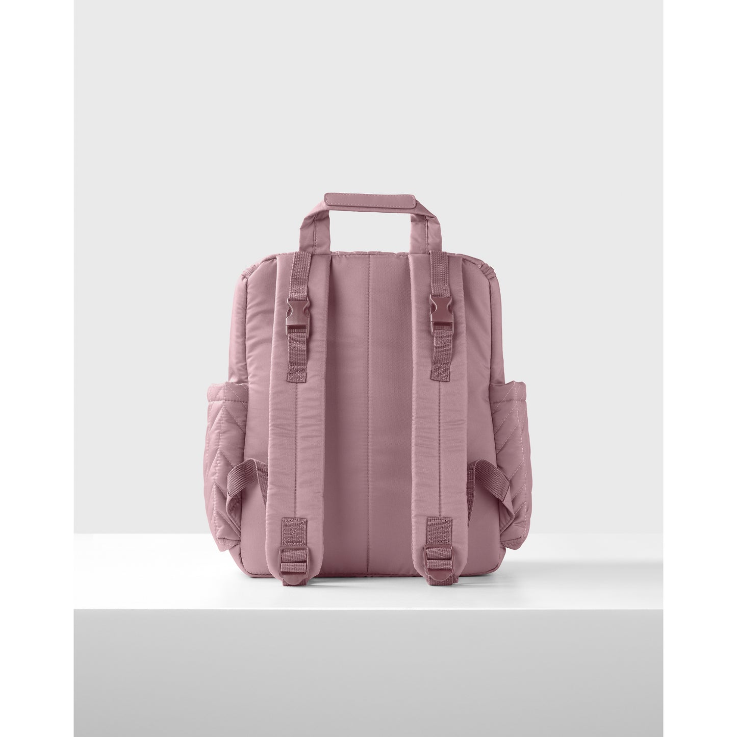 Panalera rosa SKIP*HOP visto de atrás con mochilas y compartimentos