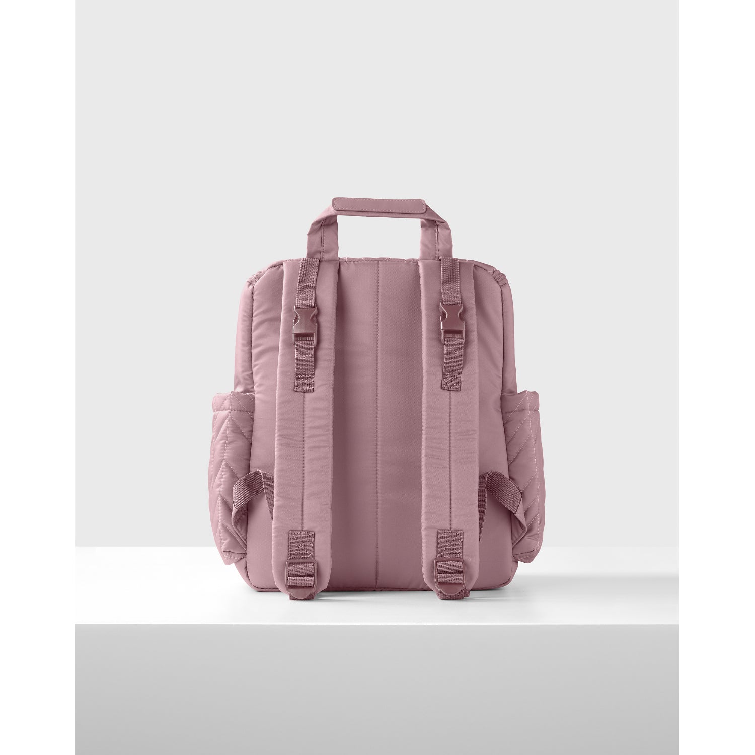 Panalera rosa SKIP*HOP visto de atrás con mochilas y compartimentos