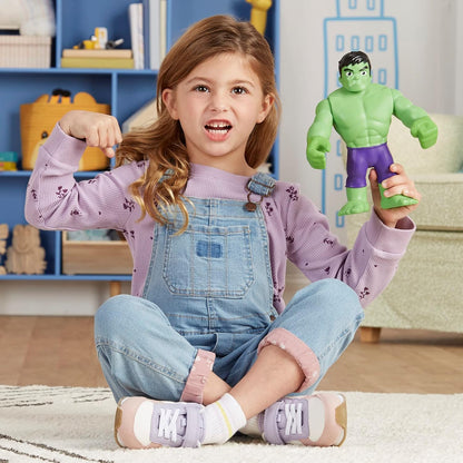Niña con figura de Hulk verde, jugando en sala de estar, expresión divertida