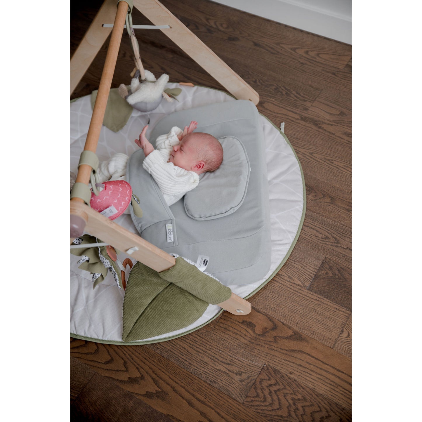 Almohadas suaves grises en colchoneta para bebés, zona de juego cómoda