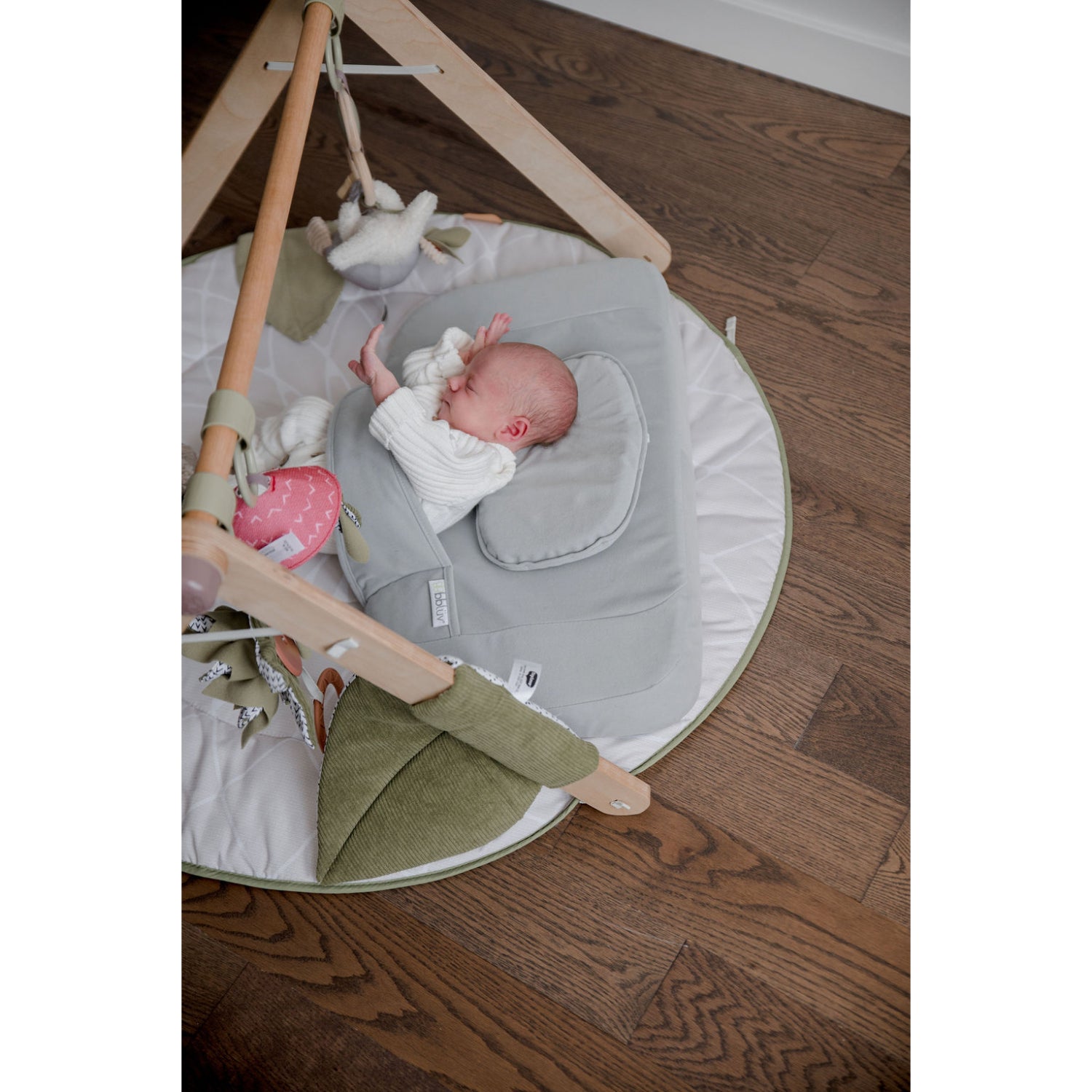 Almohadas suaves grises en colchoneta para bebés, zona de juego cómoda