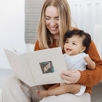 Libro para bebés de PEARHEAD color beige, madre leyendo con su hijo en casa