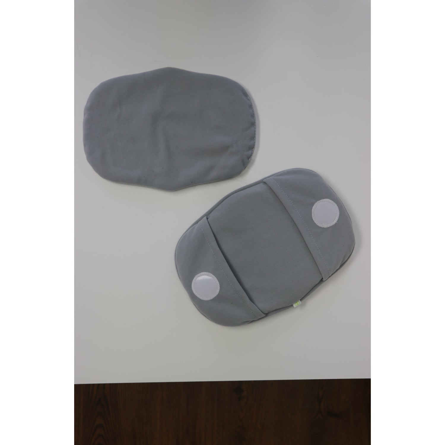 Almohadas grises BBLUV sobre mesa blanca, vista superior