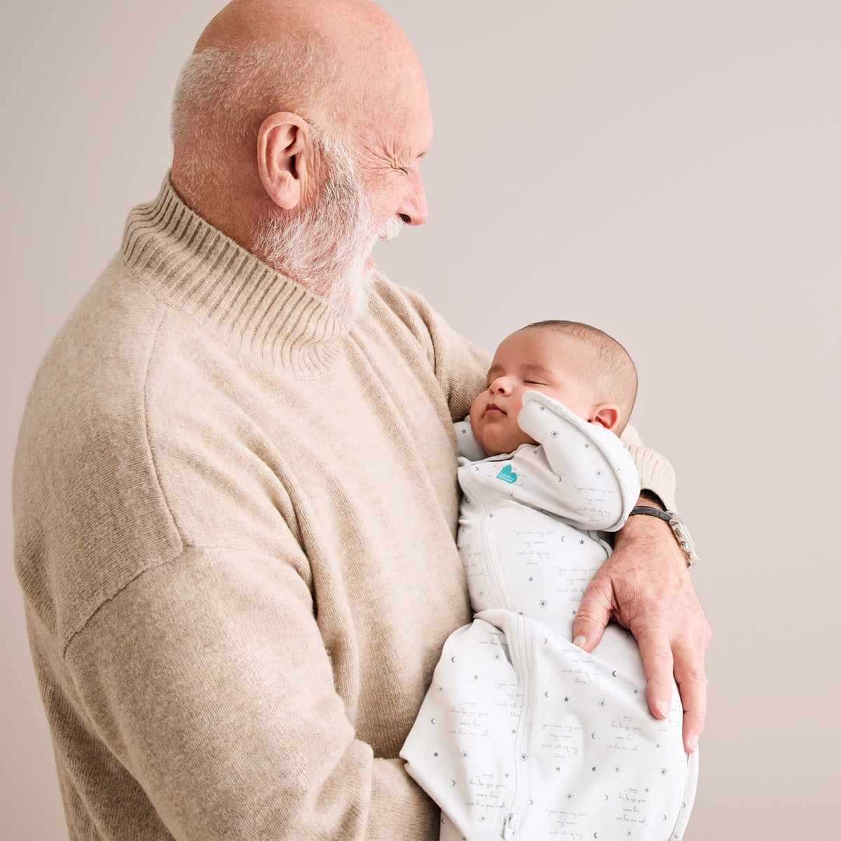 Swaddle blanco con bebé en brazos de un abuelo, ambiente acogedor.