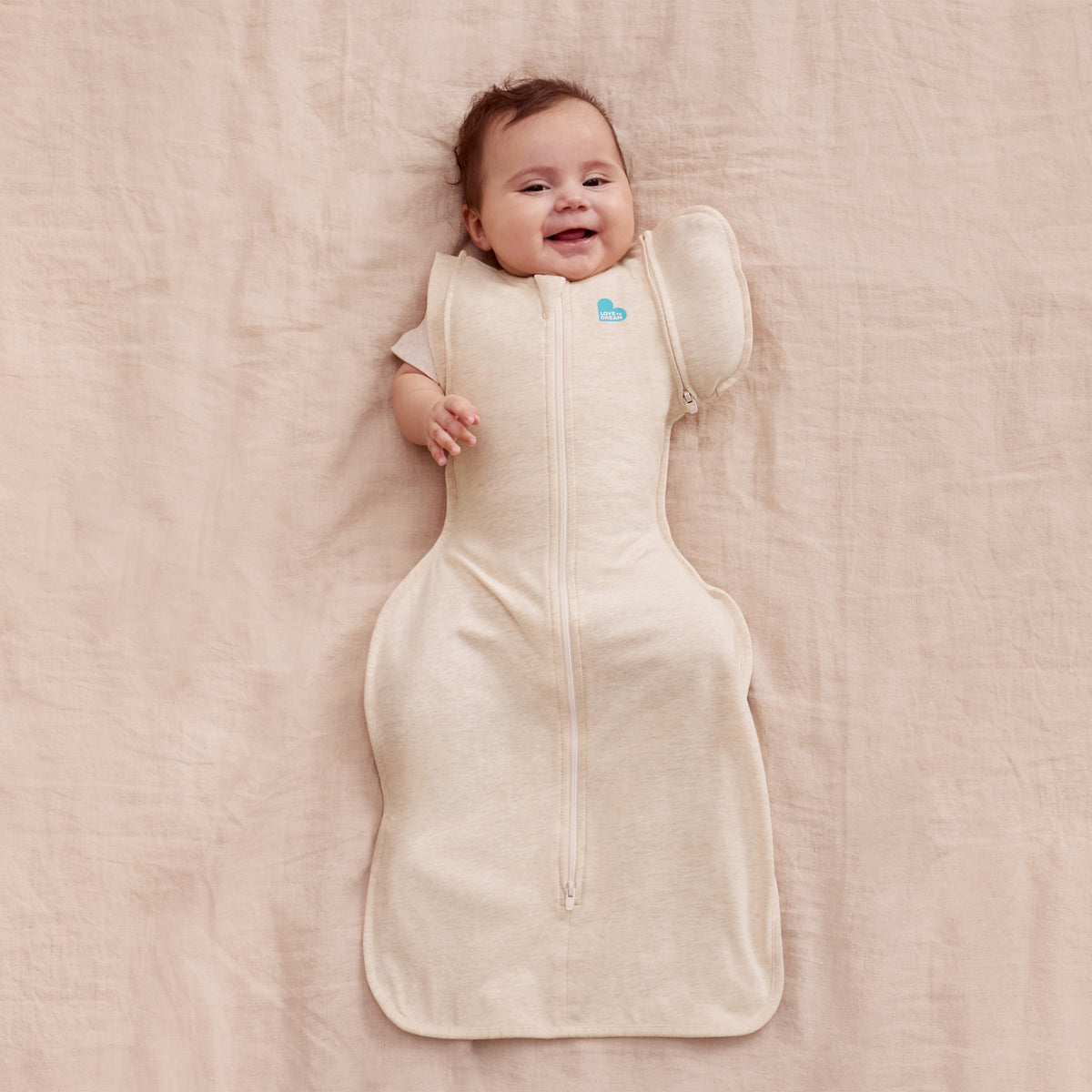 Swaddle beige LOVE TO DREAM, vista frontal con bebé feliz
