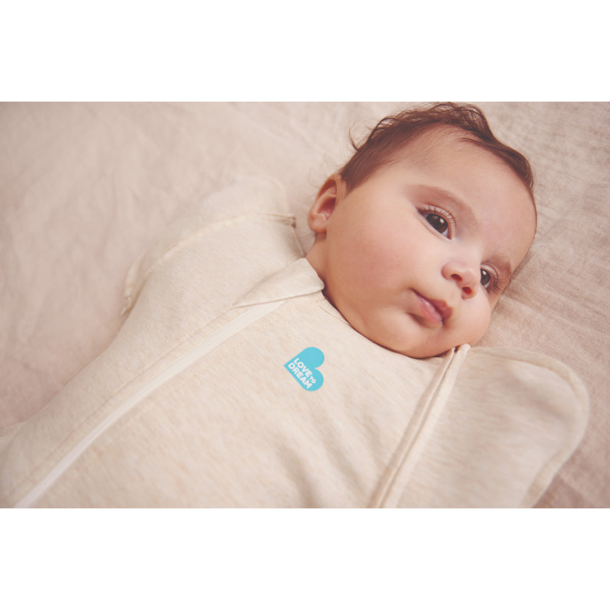 Swaddle beige LOVE TO DREAM, vista lateral del bebé, comodidad para dormir.