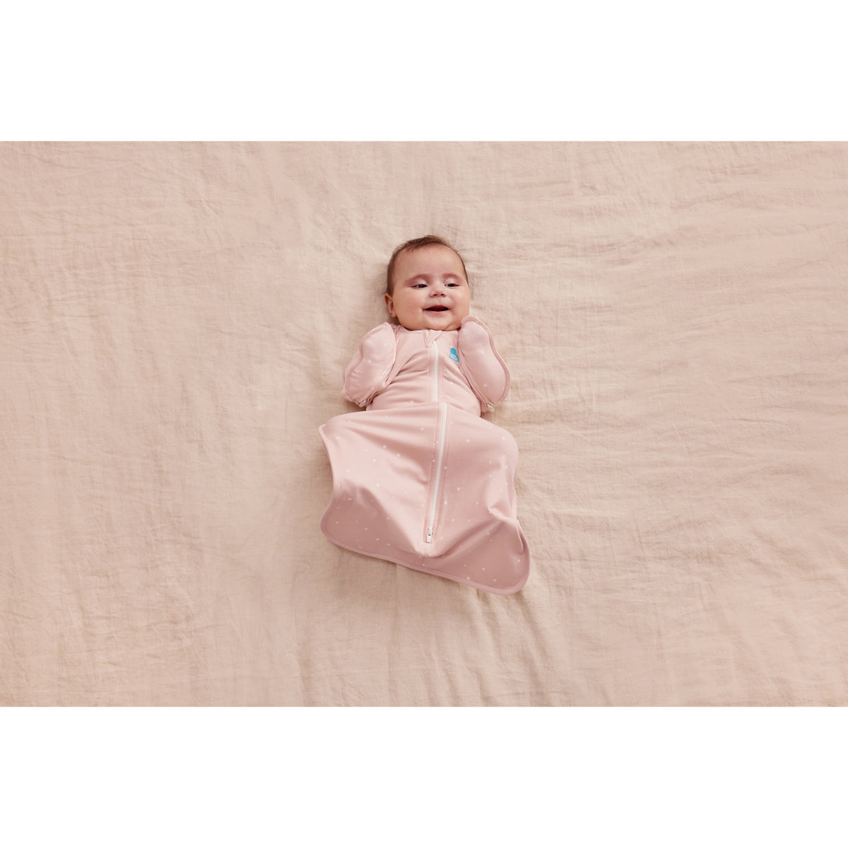 Swaddle rosa LOVE TO DREAM, vista superior, bebé sonriendo en la manta