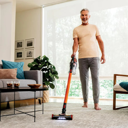Aspiradora robot para mascotas naranja, en sala de estar con muebles modernos