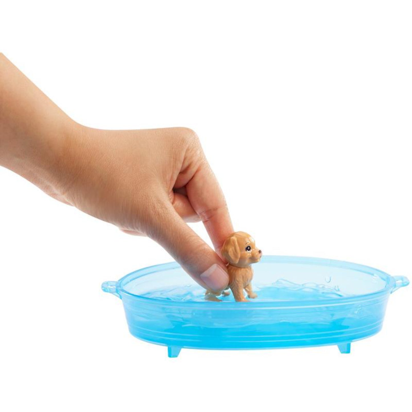 Barbie, figura de perro pequeño en un recipiente azul, mano sosteniendo el perro, contexto de juego