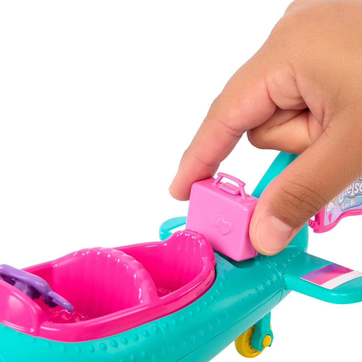 manos jugando con accesorios de la muñeca barbie en un ambiente colorido