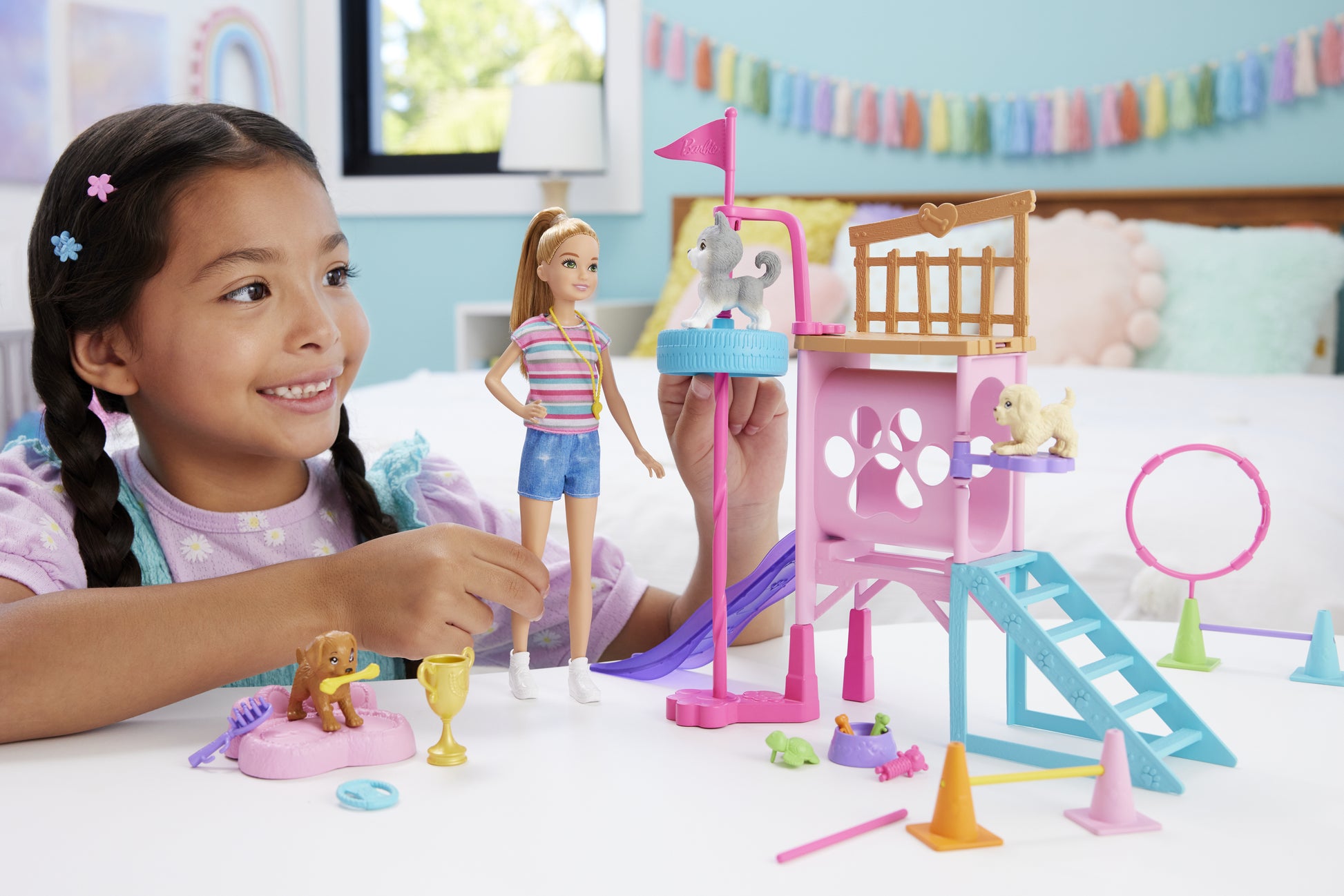 Niña con muñeca Barbie jugando en parque infantil colorido
