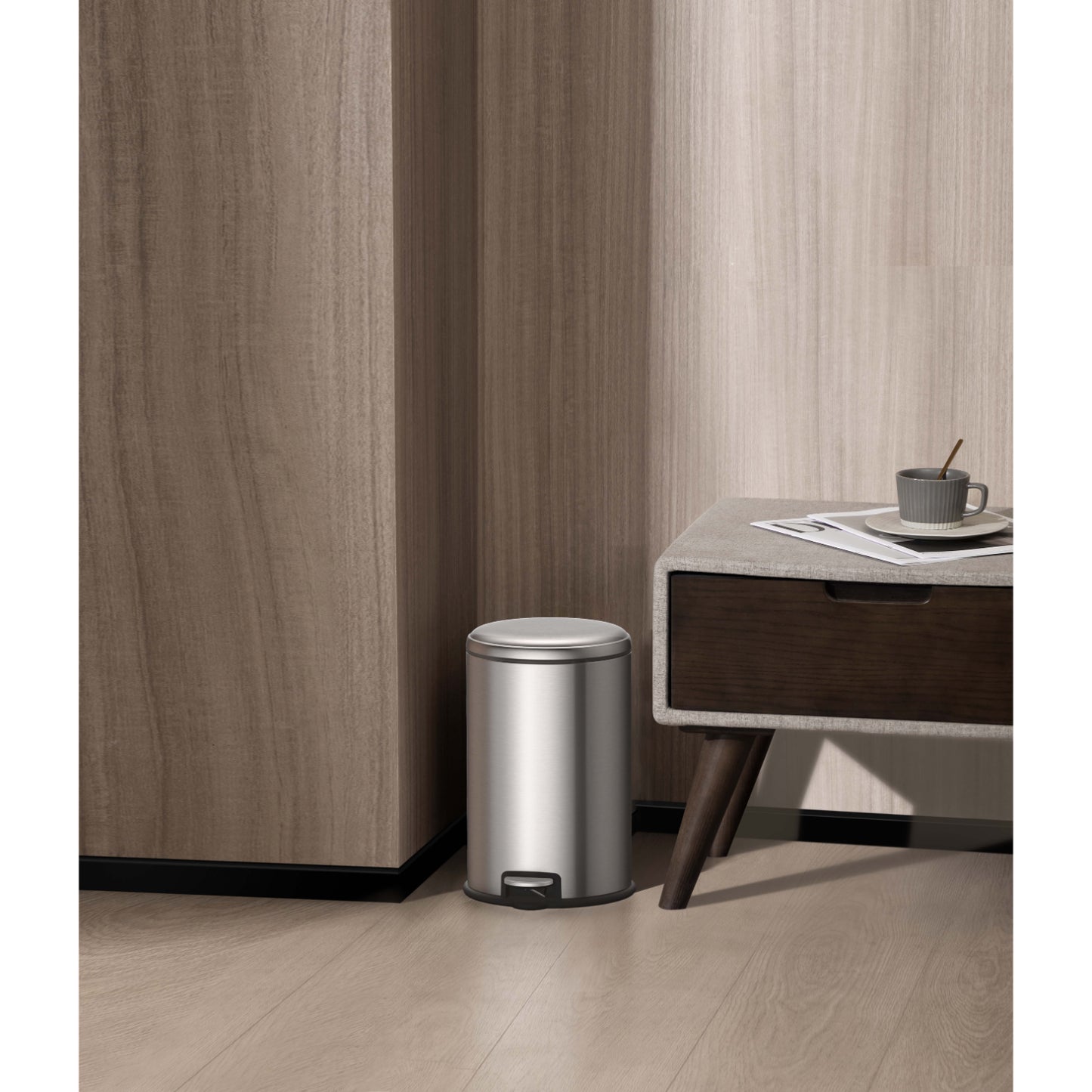 Basurero metálico con pedal EKO modelo LL02 en acero inoxidable junto a mesa auxiliar en habitación moderna