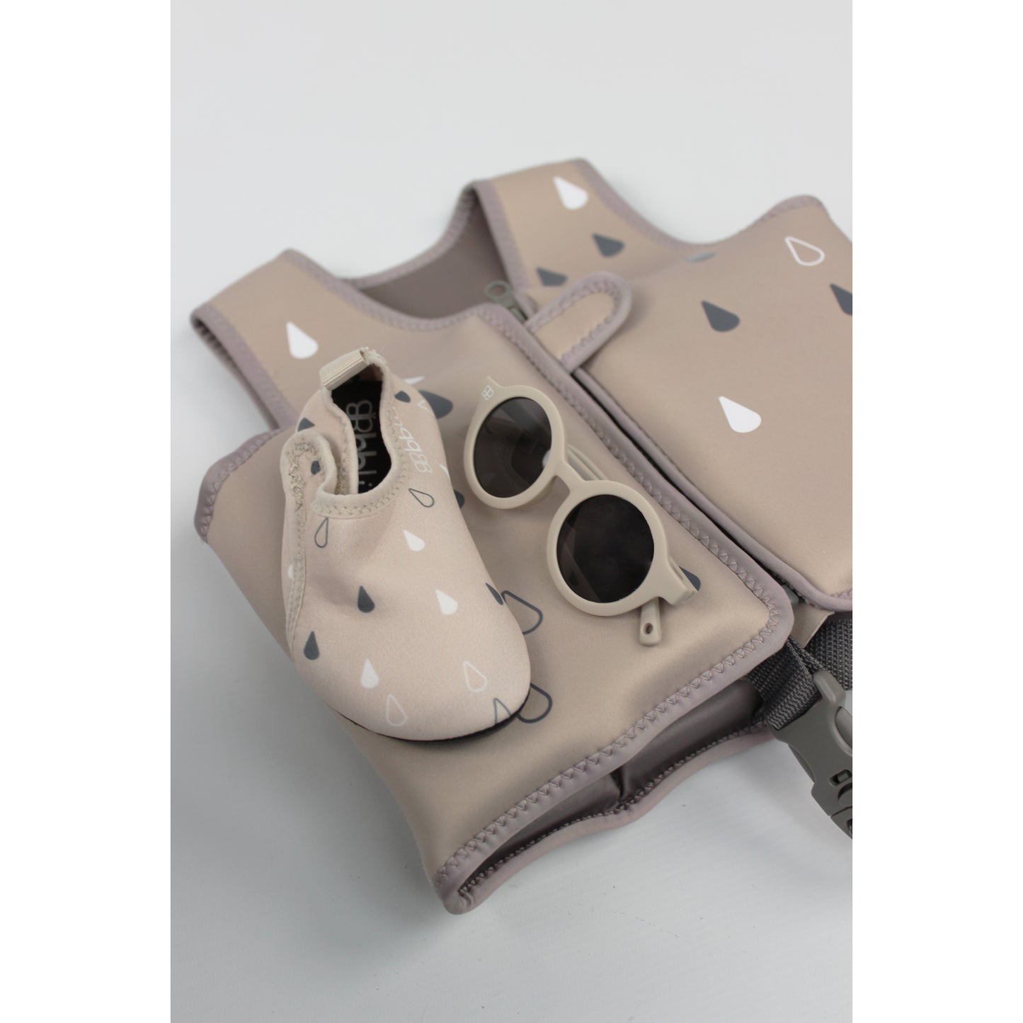 chaleco beige con gafas de sol y zapatitos, ideal para actividades al aire libre