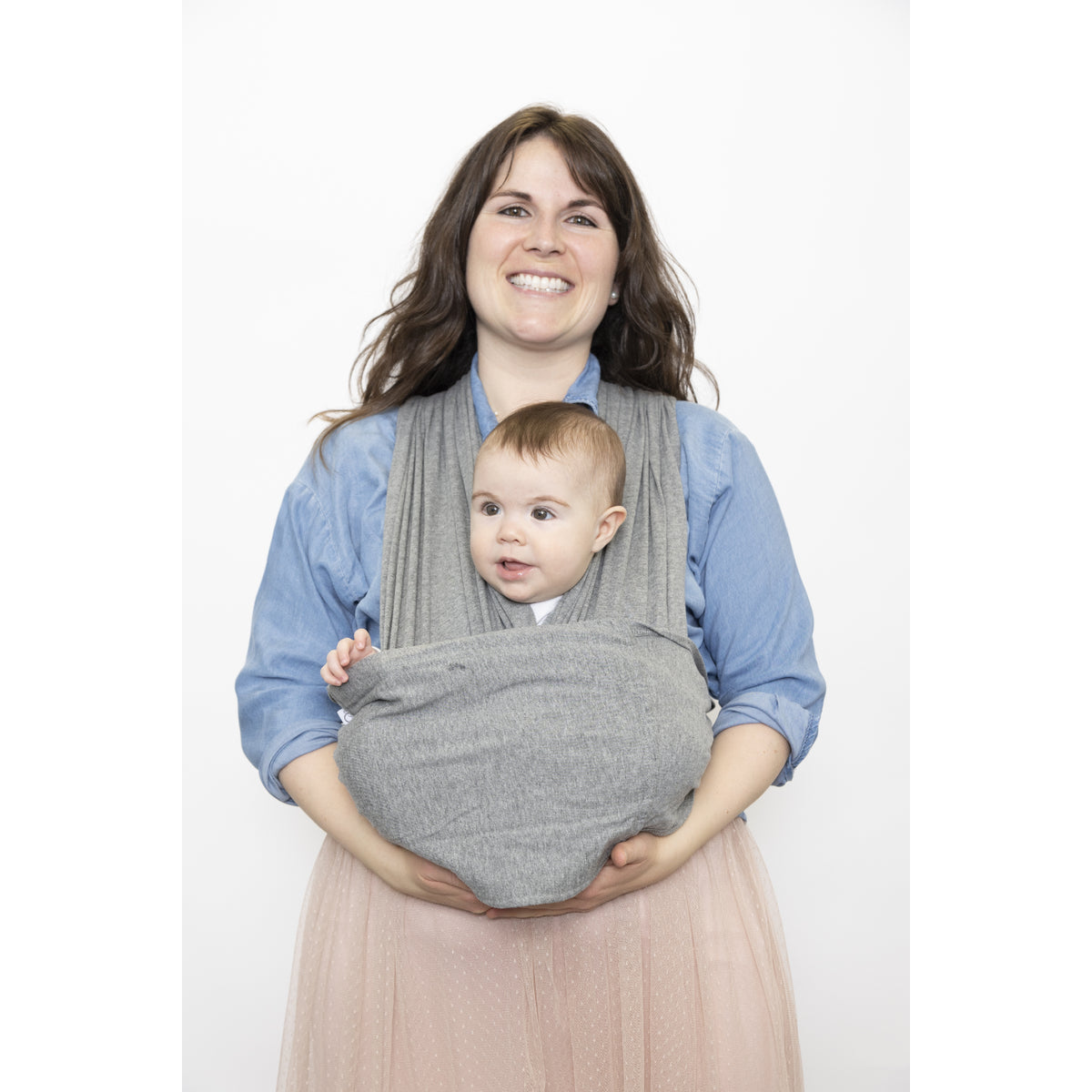 Banda portabebés gris con un bebé sonriendo, vista frontal, mamá sosteniéndolo