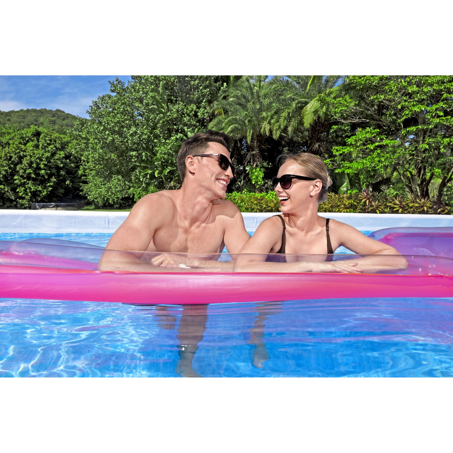 Pareja disfrutando en piscina armable para exterior, color rosa, vista desde el agua.