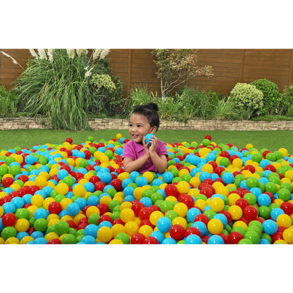 Niño feliz en una piscina de pelotas de colores para piscina en el jardín