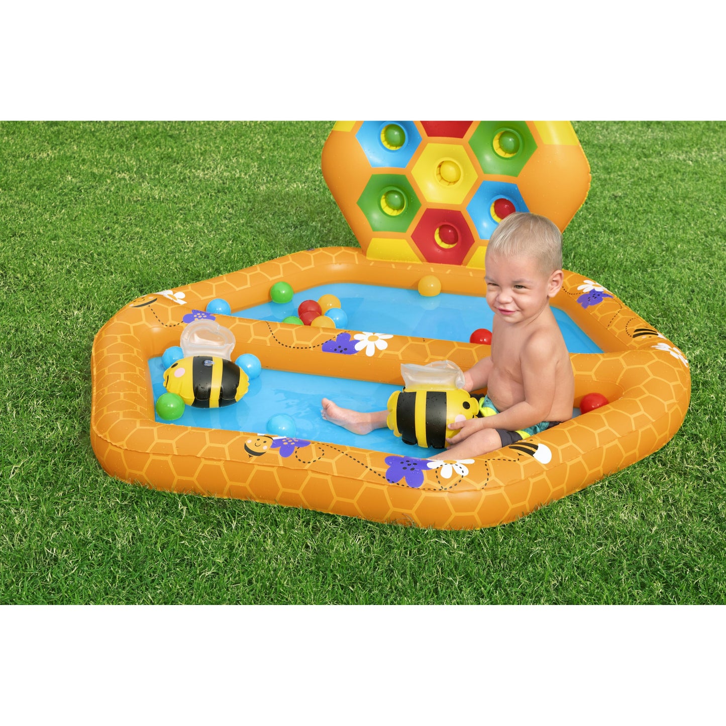 Piscina Bestway Beehive niños inflable, color amarillo, en jardín con niño jugando