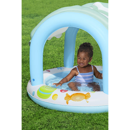 piscina infantil con sombra, color azul, vista lateral con un niño dentro