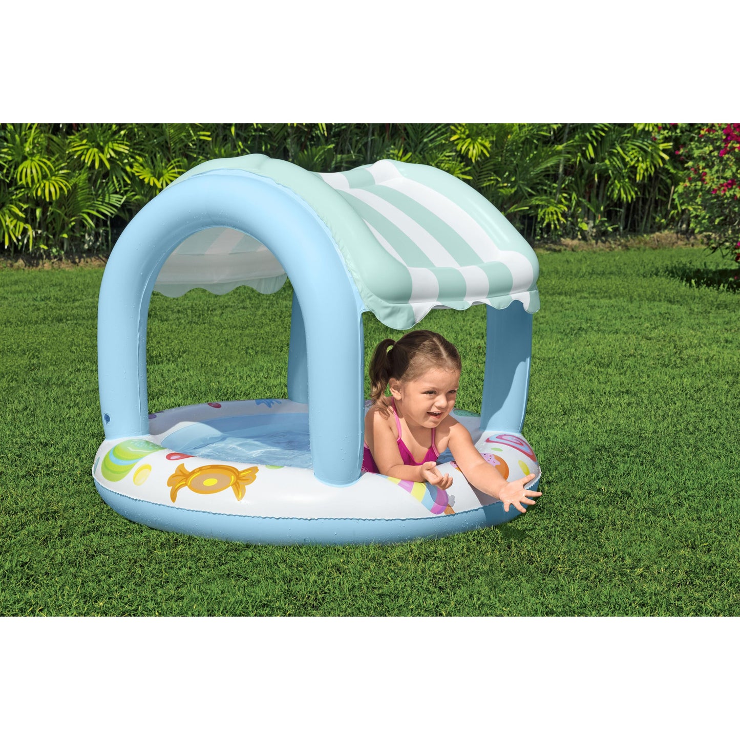 piscina infantil con sombra azul para niños, vista lateral en jardín