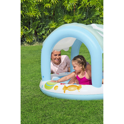 piscina infantil con sombra azul, vista lateral en jardín con niños disfrutando