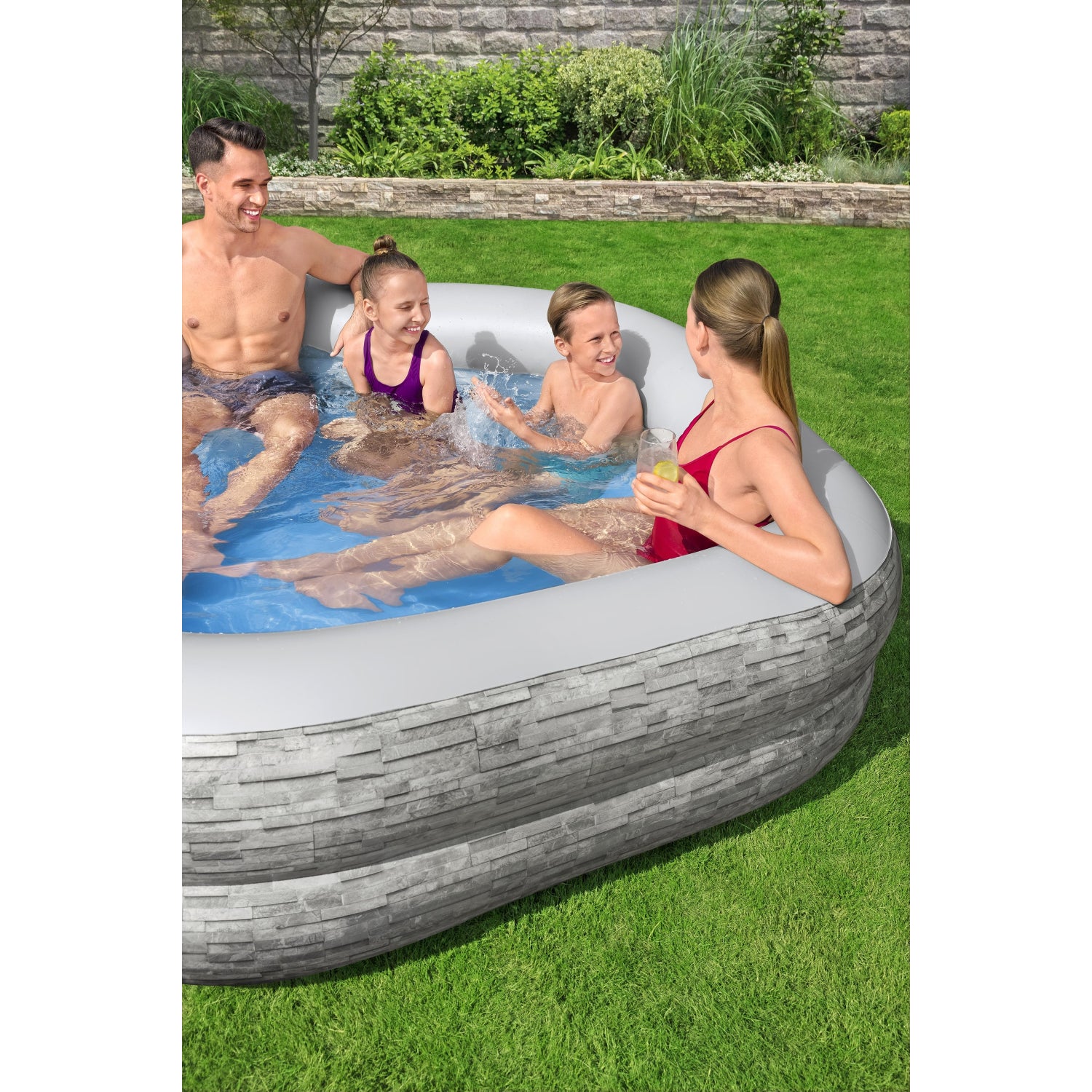 piscina inflable familiar Bestway gris con cuatro personas disfrutando en el jardín