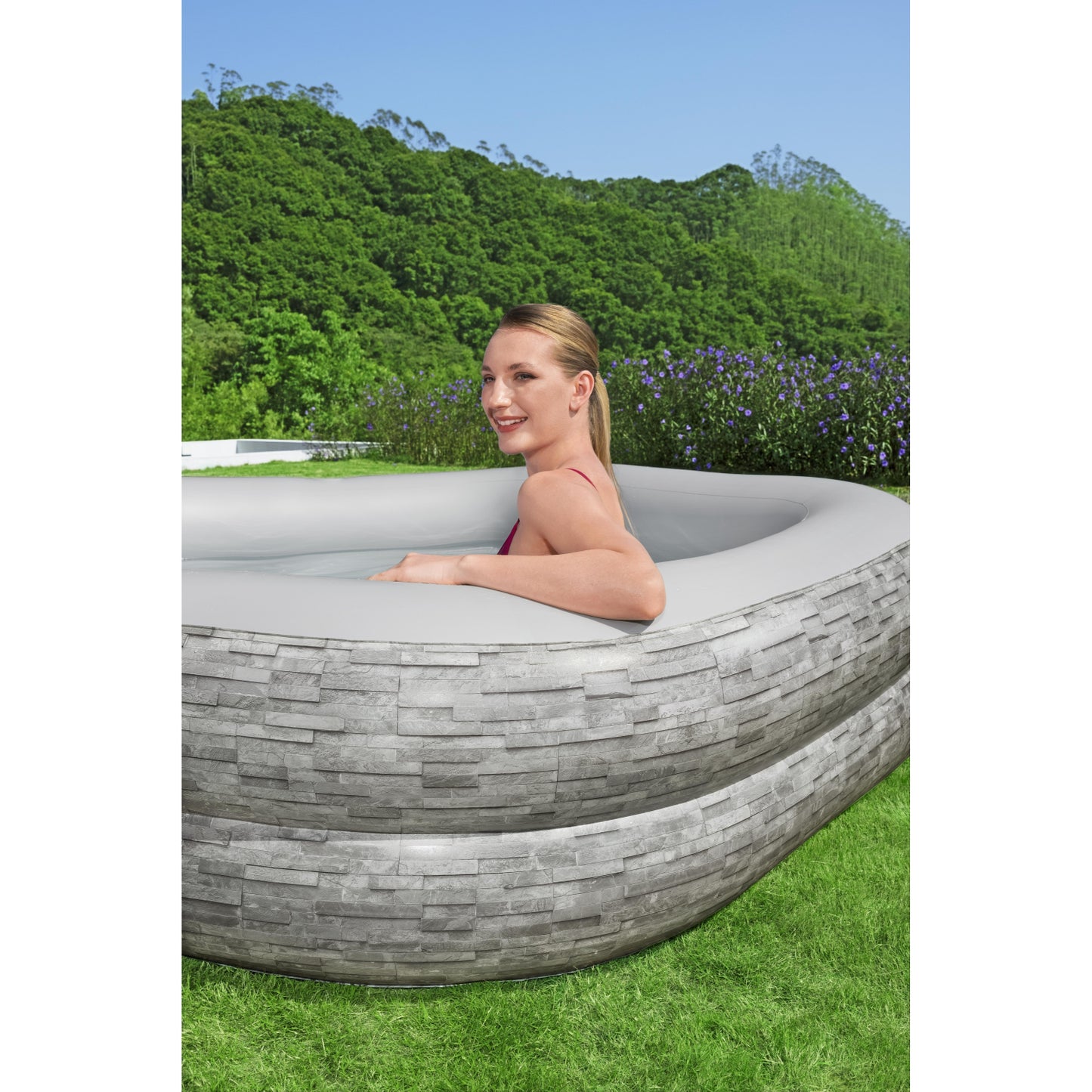 piscina inflable familiar Bestway gris, vista lateral en jardín con modelo en uso