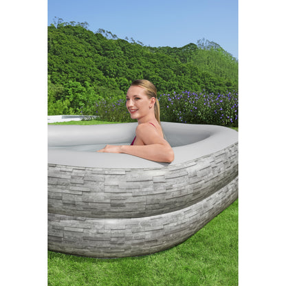 piscina inflable familiar Bestway gris, vista lateral en jardín con modelo en uso