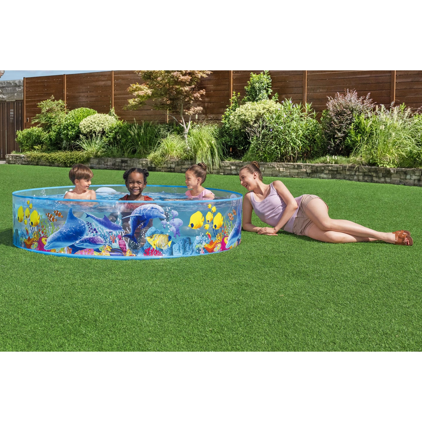 piscina redonda infantil diseños marinos, vista frontal en jardín con niños jugando