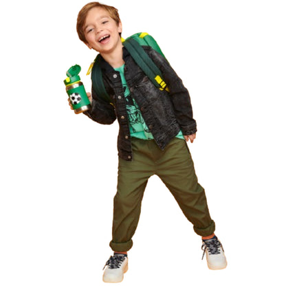 Niño feliz con botella de agua térmica verde y mochila en un ambiente divertido