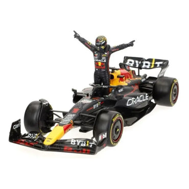 Carro F1 rojo y negro modelo con piloto de pie, vista frontal, colección de Maisto