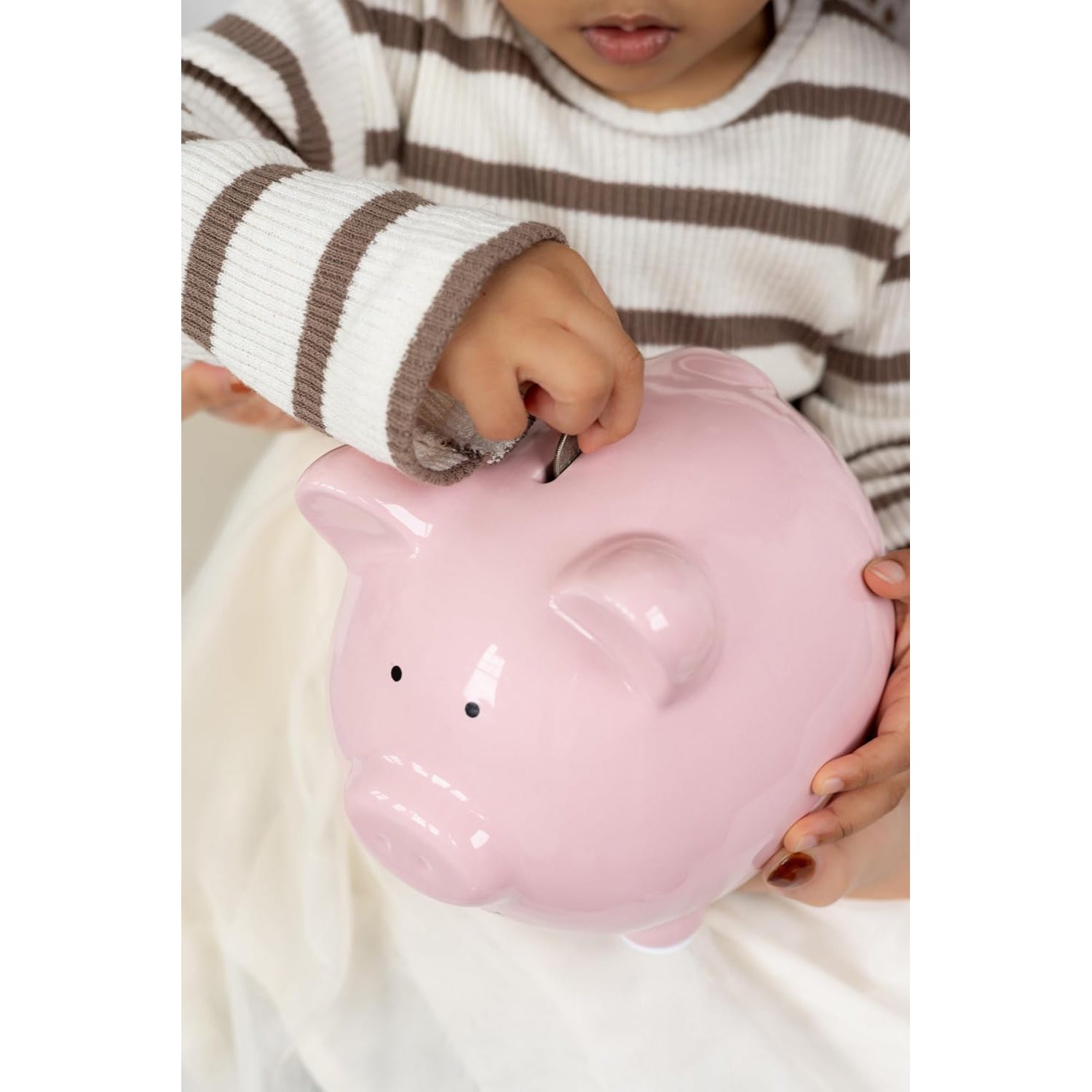 Cerdito hucha rosa en manos de un niño, ahorro y finanzas