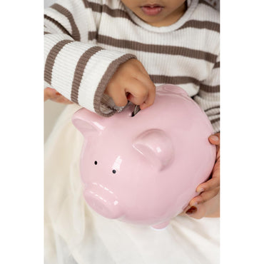 Cerdito hucha rosa en manos de un niño, ahorro y finanzas