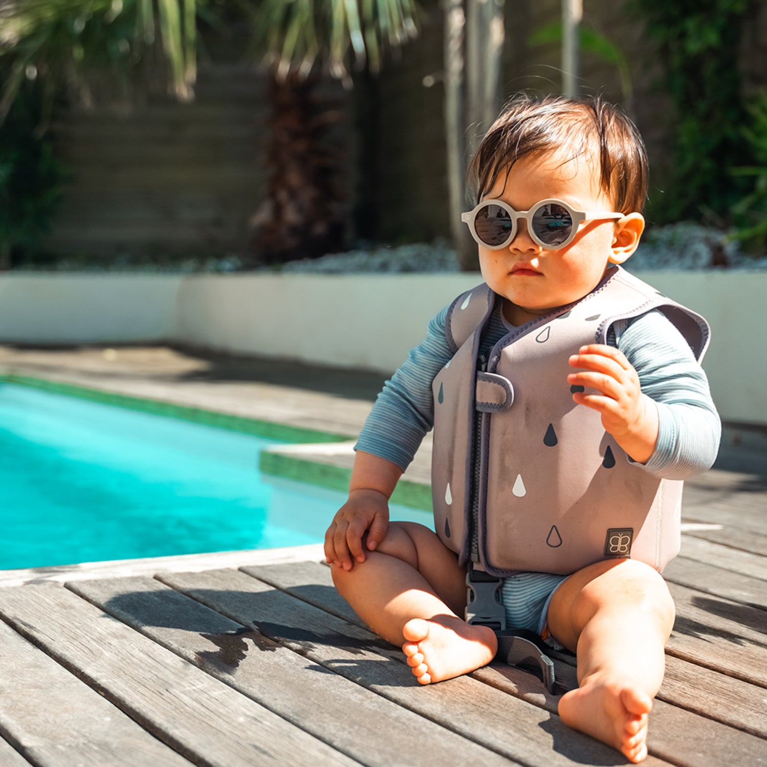 Chaleco de baño beige para bebé, vista frontal con gafas en piscina