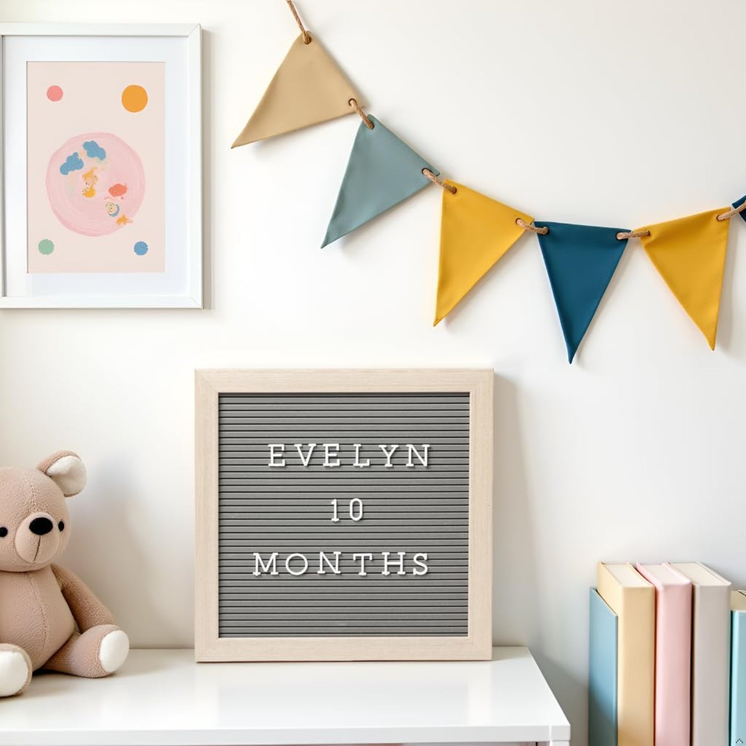 Cartel de meses gris con letras blancas, decoración infantil, mesa con peluche de oso