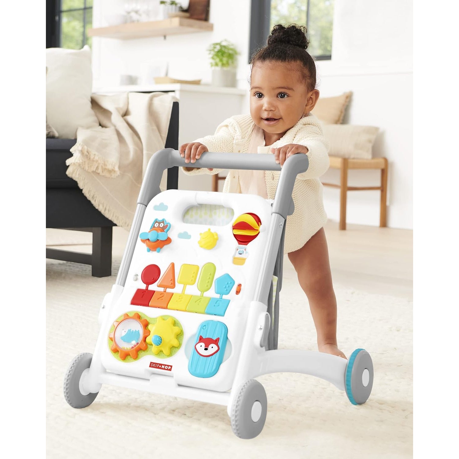 Andador para bebés SKIP*HOP, color blanco con actividades educativas, en sala de estar