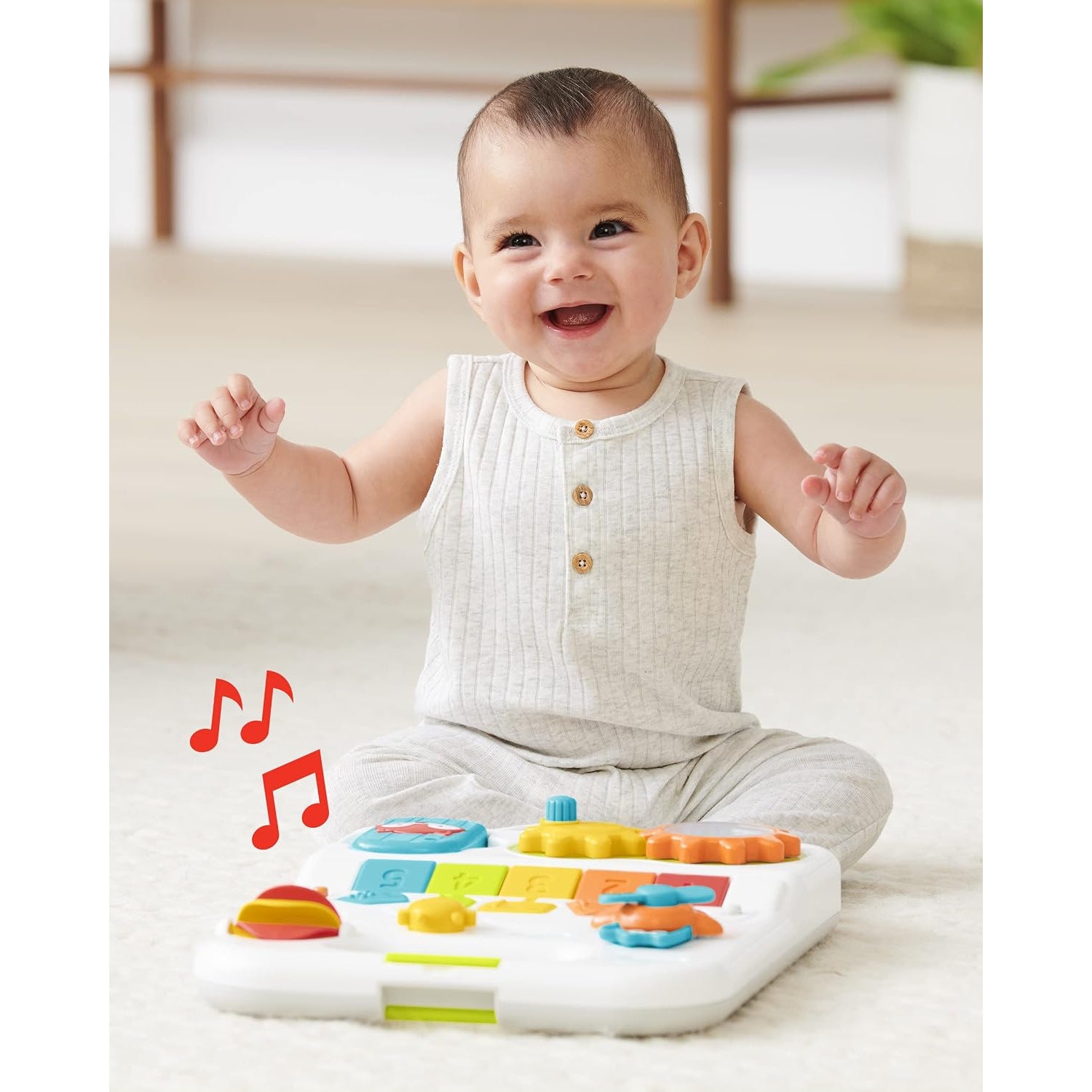 Juguete musical para bebés de SKIP*HOP, colores brillantes, bebé feliz jugando en el suelo