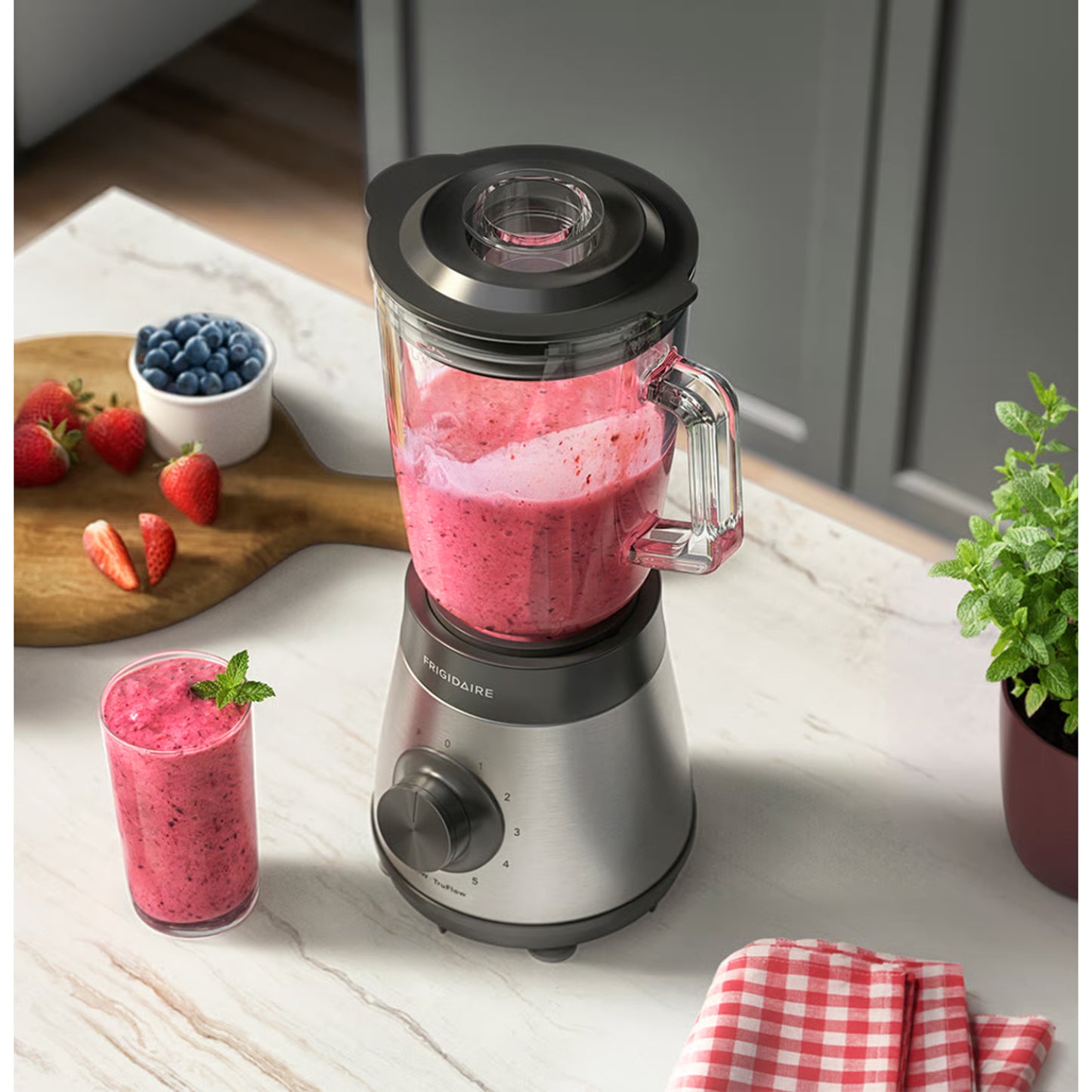 Licuadora Frigidaire 700W de acero inoxidable, preparando batido en el mostrador de cocina