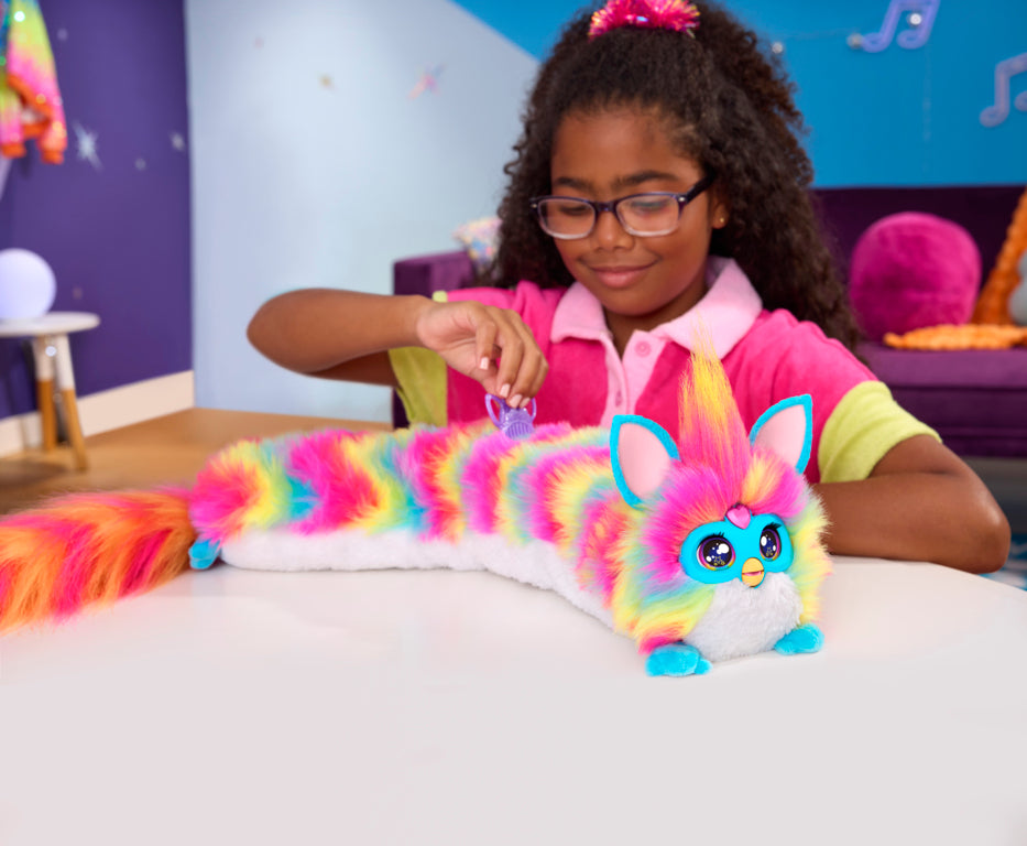 Juguete Hasbro colorido en forma de zorro, niño jugando en mesa blanca