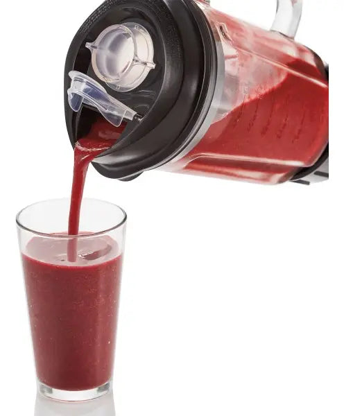 licuadora negra vertiendo batido rojo en vaso, cocina moderna