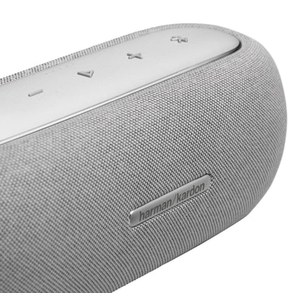 Parlante gris Harman Kardon vista lateral con controles de reproducción