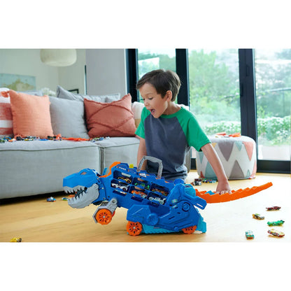 Figura de dinosaurio azul, niño jugando en casa con coches de juguete
